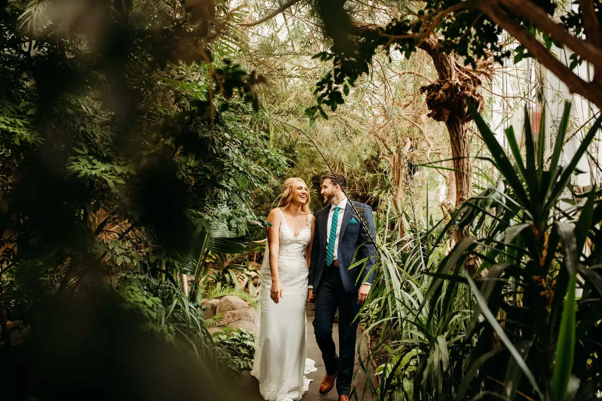 Newly married couple walking in the Discovery Center with plants surrounding them